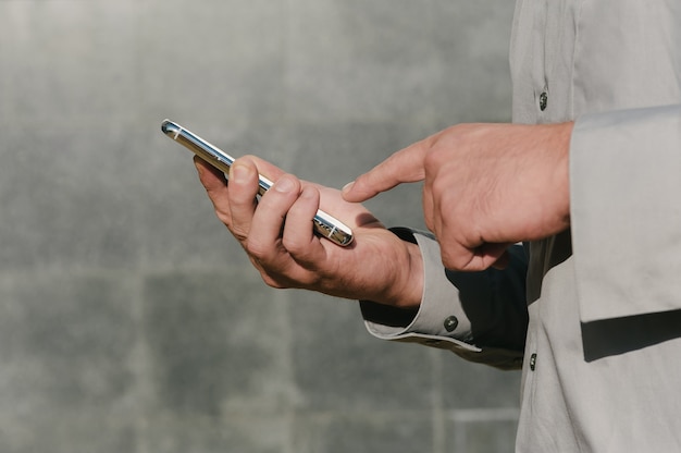 Primo piano sul telefono cellulare in bianco tenuto in mano