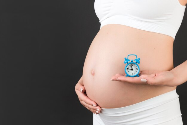 Primo piano sulla donna incinta con l'orologio