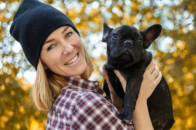Primo piano sulla giovane donna felice con il cane all'aperto in autunno