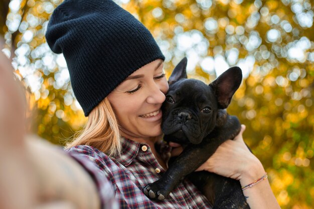 Primo piano sulla giovane donna felice con il cane all'aperto in autunno