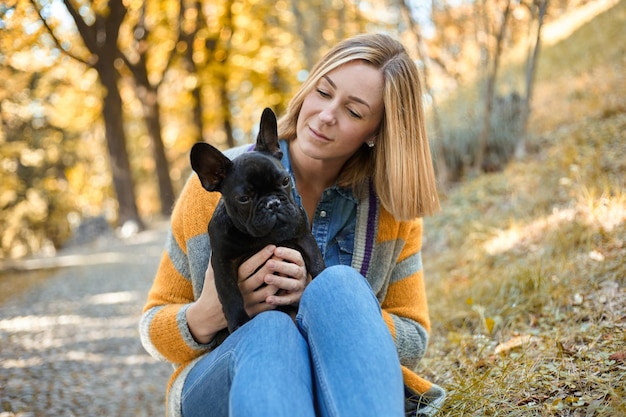 Primo piano sulla giovane donna felice con il cane all'aperto in autunno