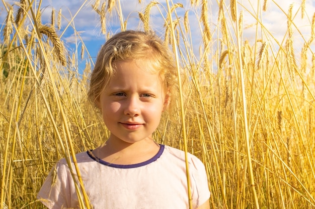 Primo piano sulla giovane ragazza bionda nel mezzo del campo di grano