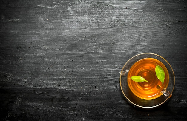 Primo piano sulla tazza di tè con foglie verdi