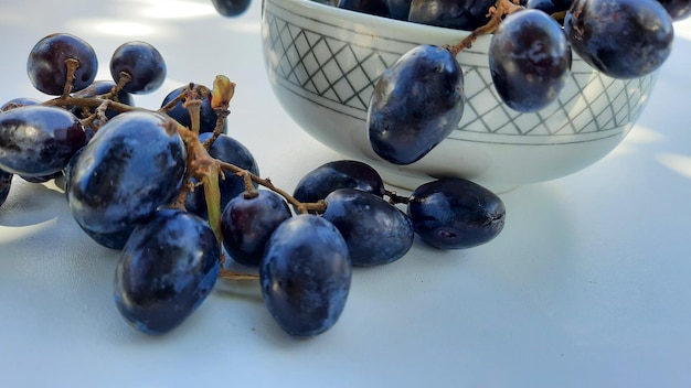 Primo piano, uva viola in una ciotola con gambo isolato su sfondo bianco 01