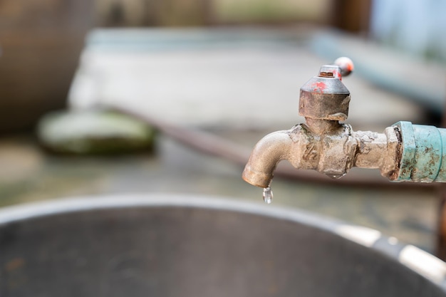 Primo piano vecchio rubinetto con perdite d'acqua Concetto di campagna per il risparmio idrico