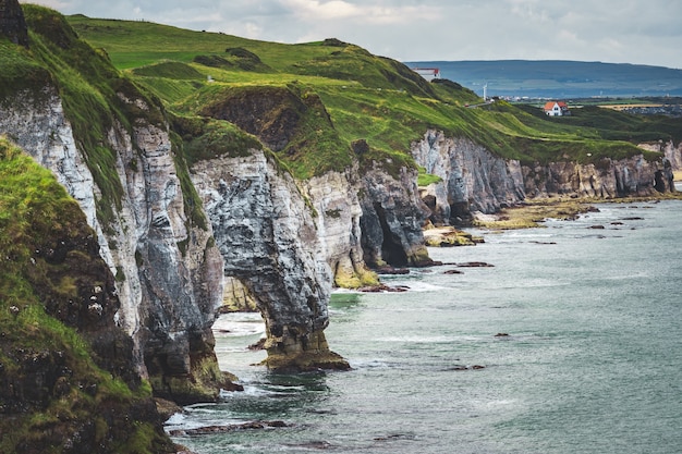 Primo piano verde scogliera coperta Irlanda del Nord litorale travolgente panoramica della baia irlandese calm