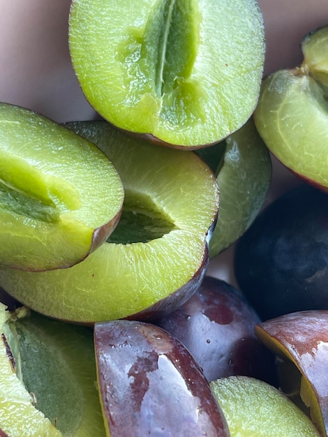 Primo piano verticale di deliziose prugne fresche tagliate a fette