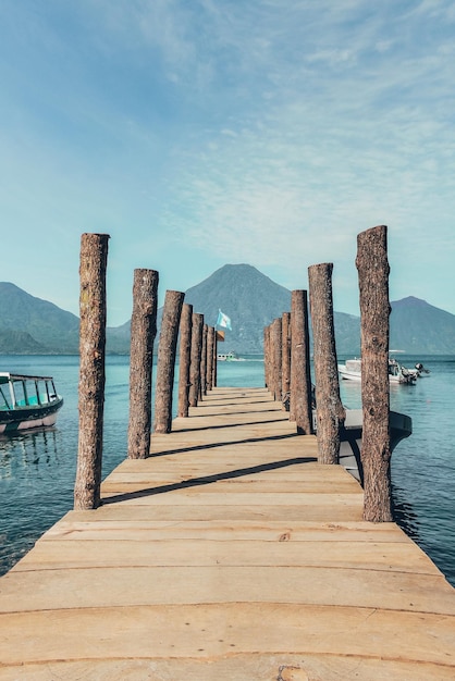 Primo piano verticale di un molo sul lago con le montagne sullo sfondo