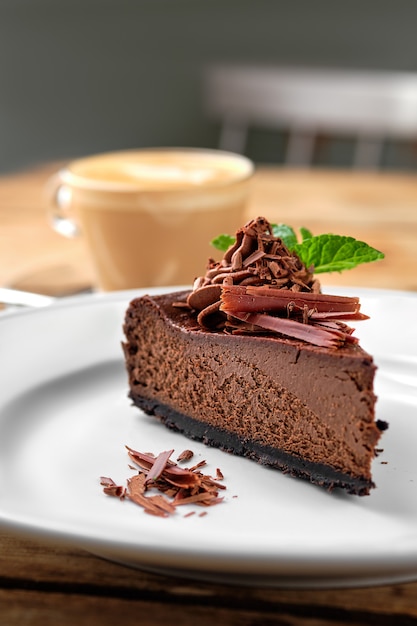 Primo piano vista del pezzo di torta al cioccolato con cappuccino