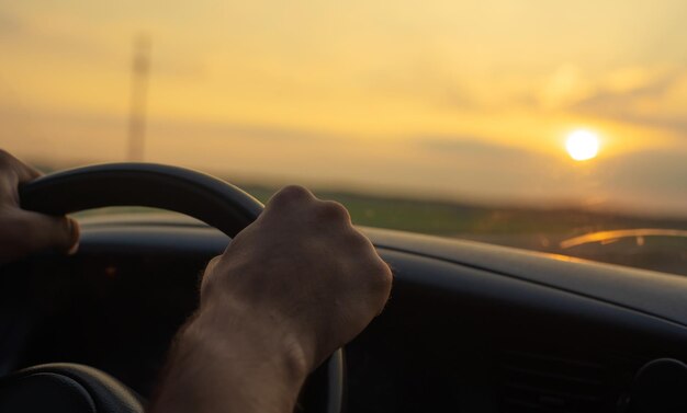 Primo piano vista laterale delle mani maschili sul volante durante il viaggio