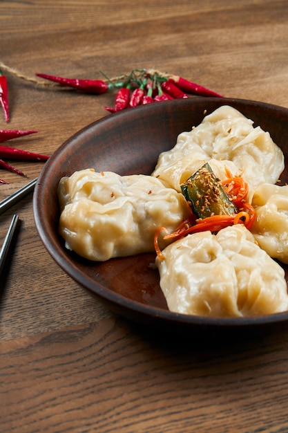 Primo piano vista su gustosi gnocchi al vapore ripieni di vari ingridients in ciotola di ceramica. Piatto tradizionale della cucina coreana - mandu o Manti