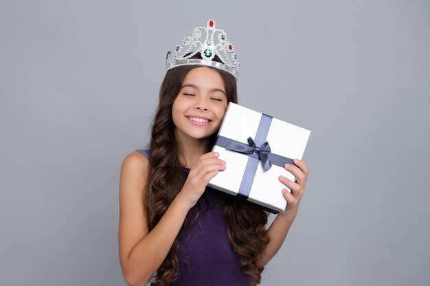 Principessa bambino in corona sognando Bambino adolescente con sfondo isolato studio scatola regalo Presente per il compleanno di San Valentino Capodanno o Natale Bambino tenere scatola regalo con fiocco nastro regalo