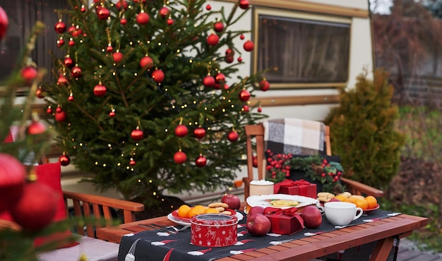 Priorità bassa dell'albero di Natale. Rimorchio mobile furgone, casa mobile, terrazza. Festa di Capodanno. Vacanze invernali. Mattina di Natale. Camper in campeggio, roulotte.