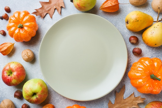 Priorità bassa di autunno con le foglie gialle, le pere delle mele delle zucche e le noci