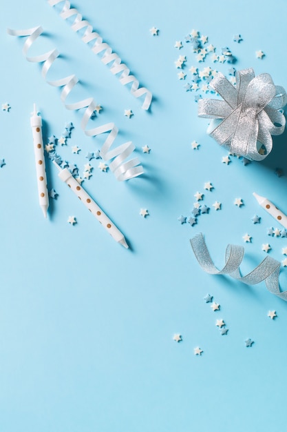 Priorità bassa di concetto di festa e compleanno con decorazione su blu, vista dall'alto, spazio di copia, verticale