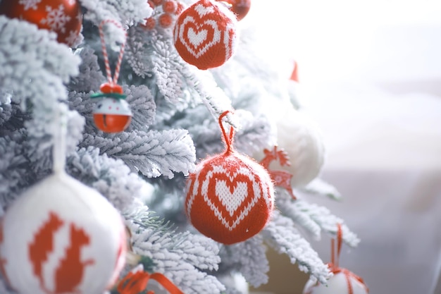 Priorità bassa di festa di Natale. Pallina d'argento e di colore appesa a un albero decorato con bokeh e neve, spazio copia.