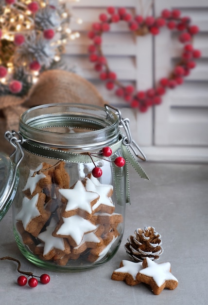 Priorità bassa di natale con i biscotti saporiti dello zenzero della stella in un vaso di vetro