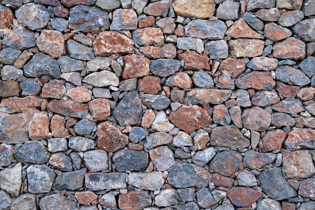 Priorità bassa strutturata delle pareti in muratura fatte di pietre multicolori