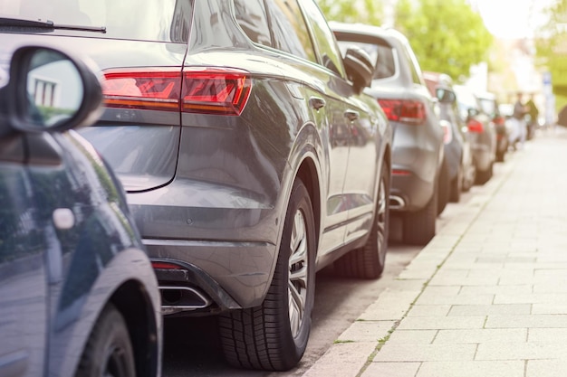 Problema di parcheggio auto Lunga fila di diverse auto parcheggiate lungo la strada Problemi di parcheggio dei veicoli