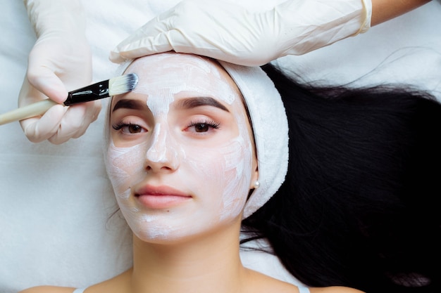 Procedura cosmetica facciale nel salone spa la procedura per applicare una maschera sul viso di una bella