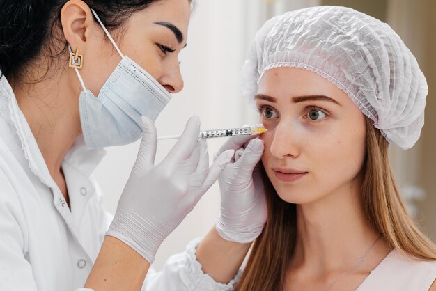 Procedura cosmetica per riempire il solco nasolacrimale e mesoterapia intorno agli occhi per una giovane e bella ragazza Cosmetologia moderna