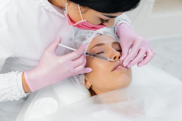 Procedura di cosmetologia per l'aumento delle labbra e la rimozione delle rughe per una giovane donna