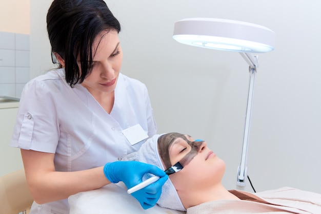 Procedura di peeling facciale al carbonio nella clinica di cosmetologia laser.