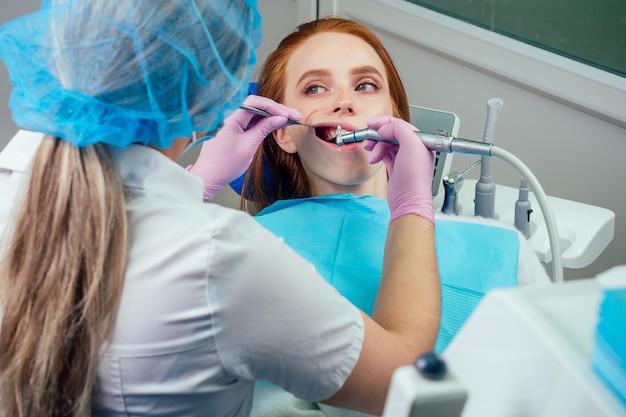 Procedura di perforazione dentale e controllo su denti belli e bocca aperta.