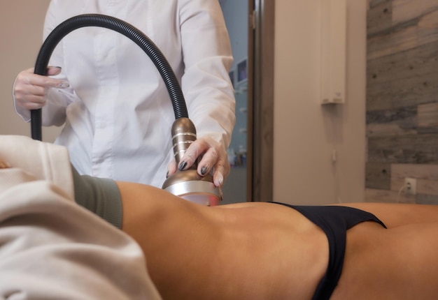 Procedura di rimozione della cellulite sull'addome femminile cavitazione massaggio del ventre Massaggio ad ultrasuoni per dimagrire Correzione della figura femminile senza intervento chirurgico Primo piano del ventre