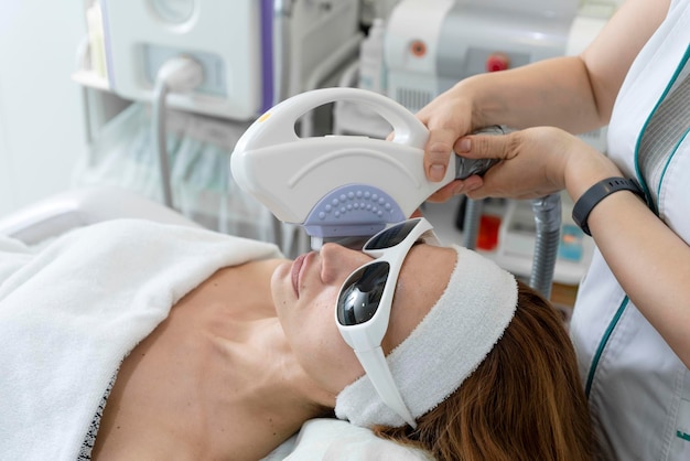 Procedure antietà Concetto di cura della pelle Donna che riceve un trattamento viso laser rimuovendo la pigmentazione presso la clinica cosmetica Terapia con luce pulsata intensa IPL Fototerapia facciale di ringiovanimento