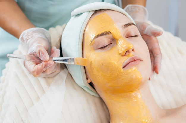 Procedure di cura del viso per le giovani donne nella moderna clinica di cosmetologia