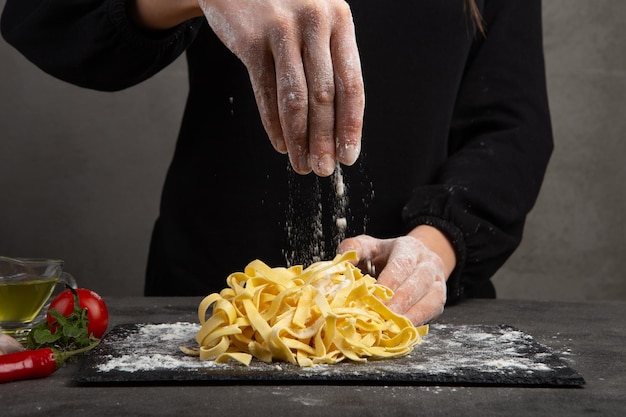 Processo di cottura della pasta italiana Concetto di cibo fresco Tagliatelle fatte in casa