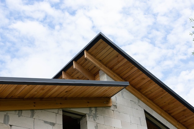 Processo di lavorazione, costruzione suburbana da blocchi di silicato e gas silicato e legno. La cornice di una casa a un piano con tetto.