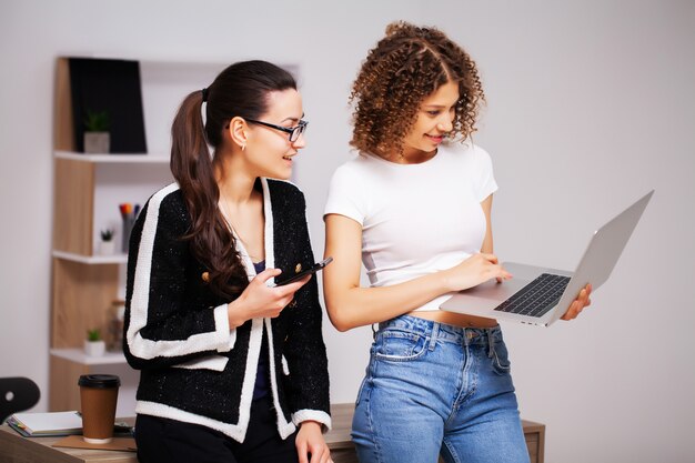 Processo di lavoro di squadra. Due donne con il computer portatile nel lavoro insieme