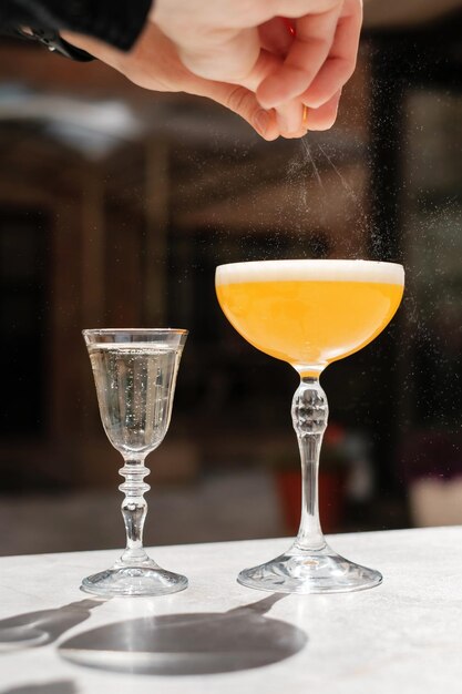 Processo di preparazione del cocktail Il barista spreme la scorza di limone