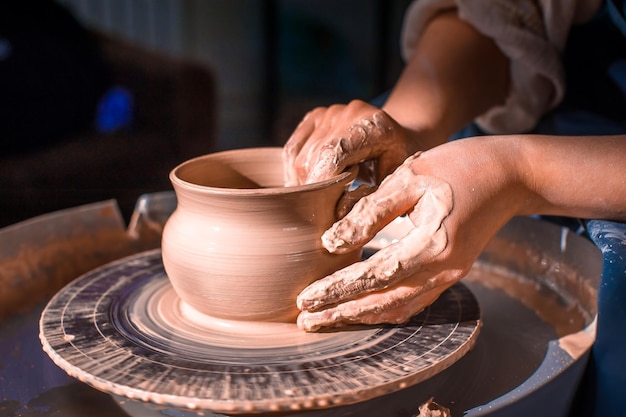 Processo di produzione della ceramica. Formare una teiera di argilla su un tornio da vasaio.