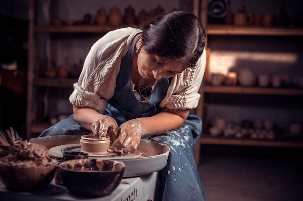 Processo di produzione della ceramica. Formare una teiera di argilla su un tornio da vasaio.