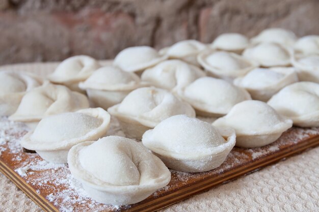 Processo di produzione di pelmeni fatti in casa su tavola di legno