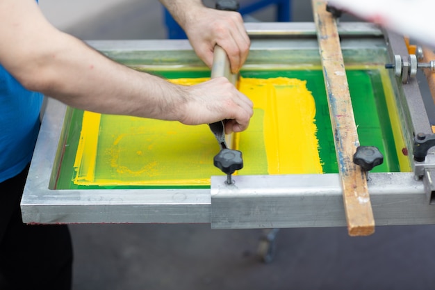 Processo di stampa serigrafica serigrafica presso la fabbrica di vestiti racla telaio e vernici colorate plastisol