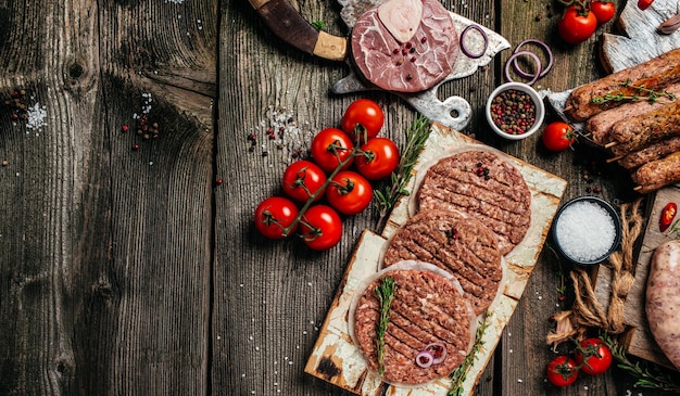 Prodotti a base di carne cruda diverse parti del corpo carne di manzo macinata spiedini di maiale manzo pollo su uno sfondo di legno banner menu ricetta posto per testo vista dall'alto