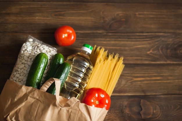 Prodotti alimentari Un sacchetto di carta con una scorta di cibo da prodotti di conservazione a lungo termine e verdure