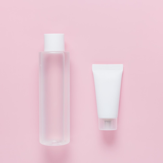 Prodotti cosmetici per la cura del viso di colore bianco su sfondo rosa Toner per maschera facciale Beauty Cream