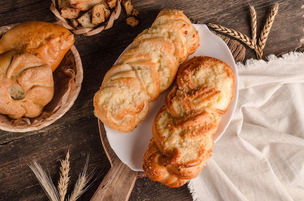 Prodotti da forno freschi - deliziosi panini di vimini con ripieno su fondo in legno