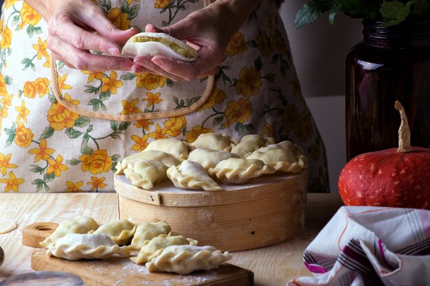 Prodotti da forno tradizionali ucraini - Realizzazione di pierogie da mani femminili. Stile rustico. Foto retrò