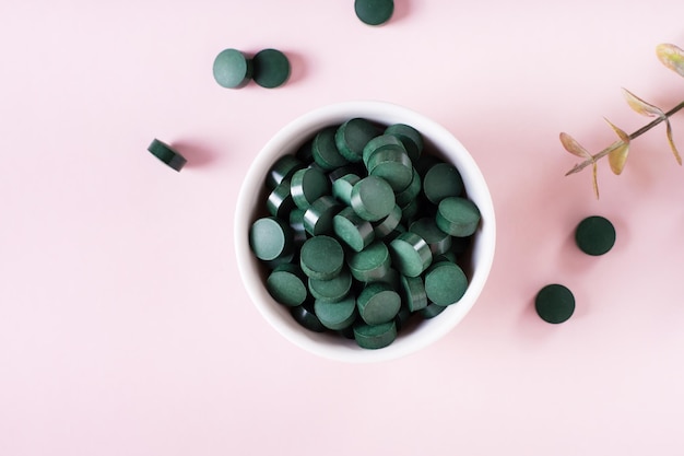 Prodotti Detox Alghe Spirulina in pillole e polvere di tè matcha in ciotole Vista dall'alto Primo piano