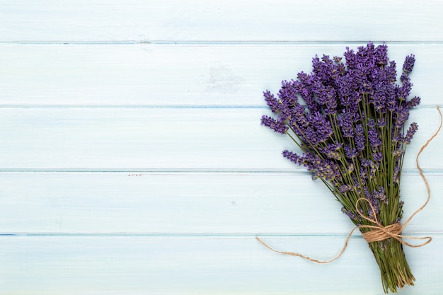 Prodotti governare e mazzo fresco della lavanda sul fondo di legno bianco della tavola.