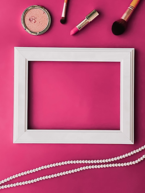 Prodotti per il trucco con cornice artistica orizzontale bianca e gioielli di perle su sfondo rosa come stampa di opere d'arte dal design piatto o album fotografico