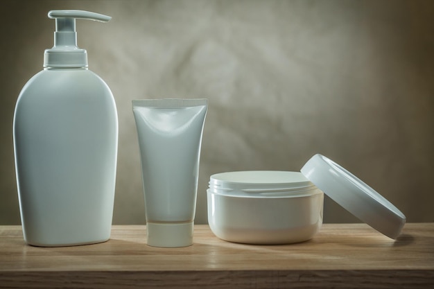 Prodotti per l'igiene del corpo due erogatori a pompa mockup di bottiglie di plastica bianche vuote e crema per il viso in un vasetto aperto su un tavolo di legno