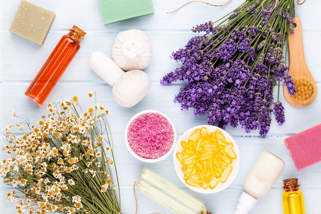 Prodotti per la toelettatura e bouquet di lavanda fresca sul fondo della tavola in legno bianco.