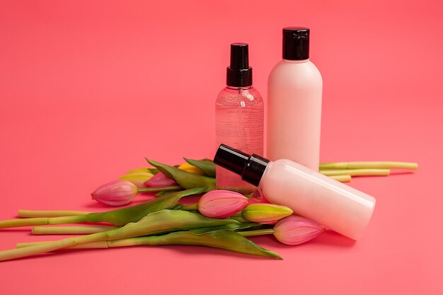 prodotto cosmetico di bellezza in bottiglia con concetto di assistenza sanitaria per la cura della pelle su sfondo rosa
